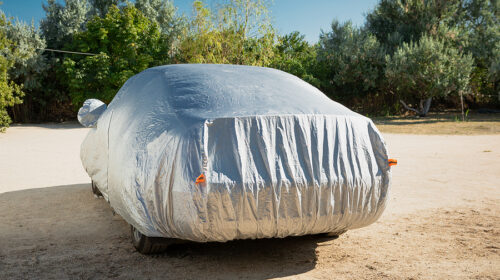 The car is in the parking with auto cover from the sun. Protecti